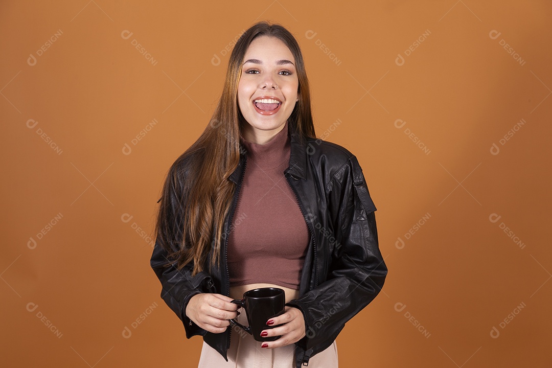 Uma linda jovem de cabelos claros com jaqueta segurando xícara e sorrindo