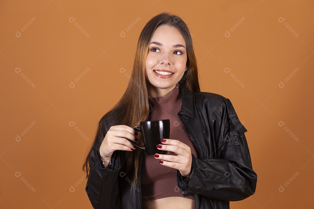 Uma linda jovem de cabelos claros com jaqueta segurando xícara