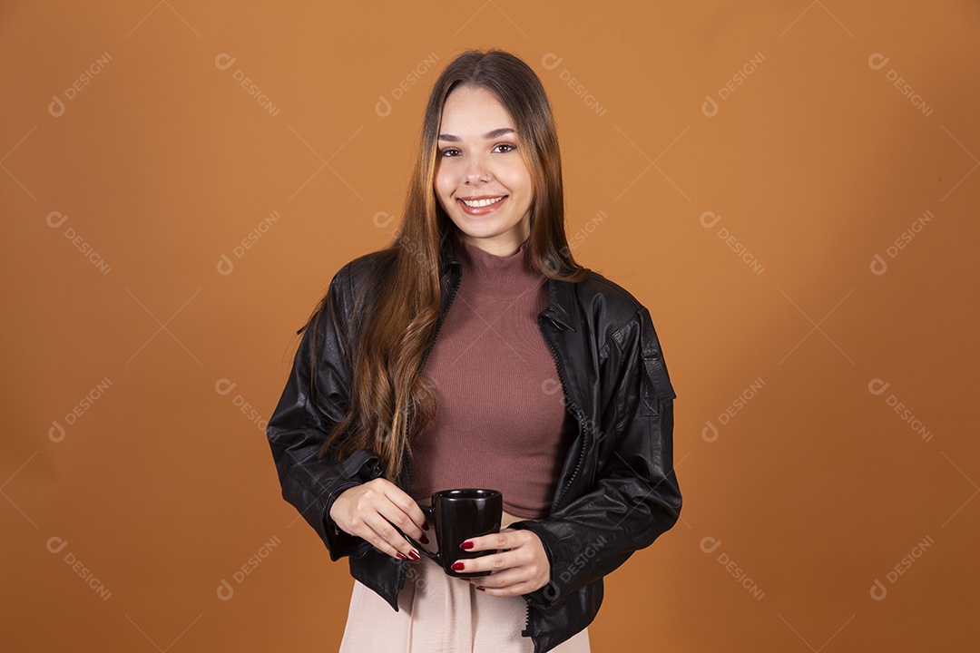 Uma jovem linda sorrindo com xícara nas mãos sobre fundo claro