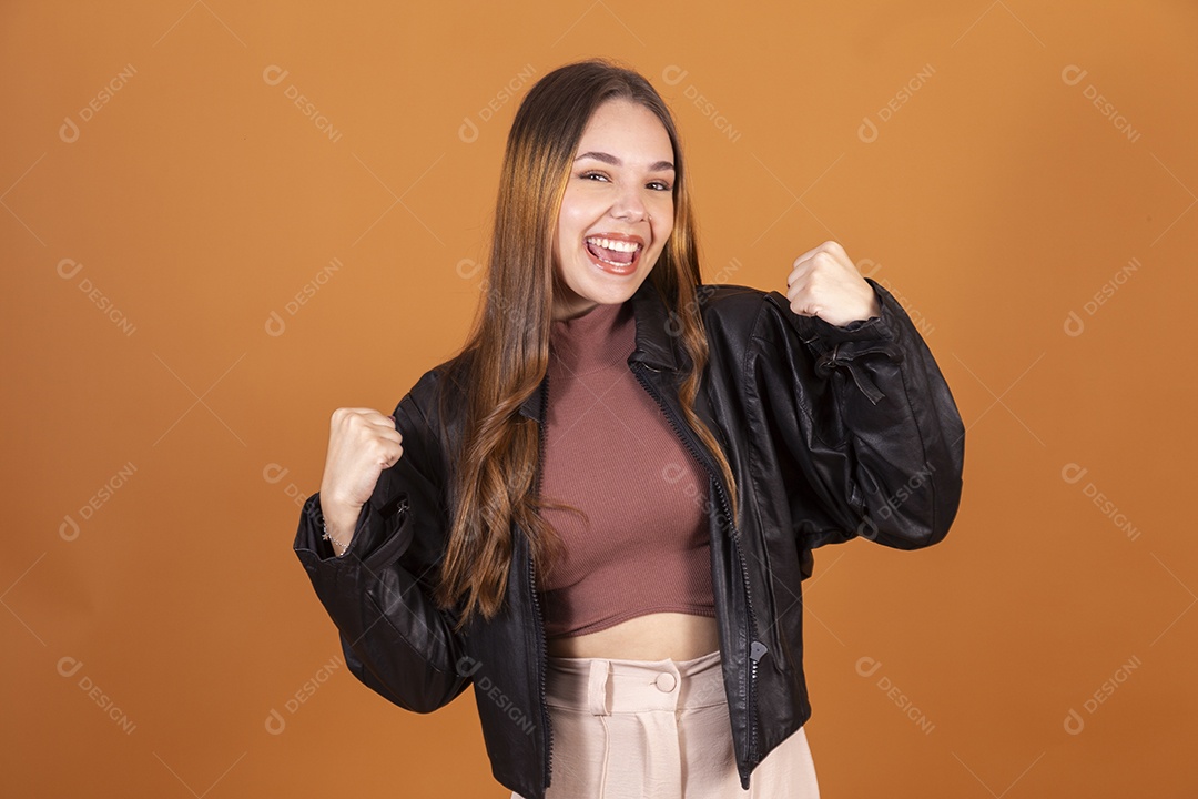 Jovem garota sorrindo demonstrando força com jaqueta preta