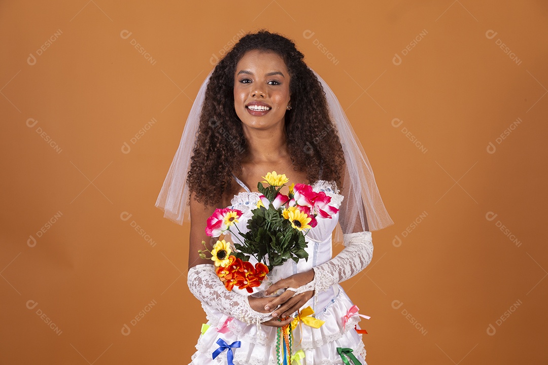 Jovem morena de cabelos cacheados vestida de noiva fazendo pose para foto