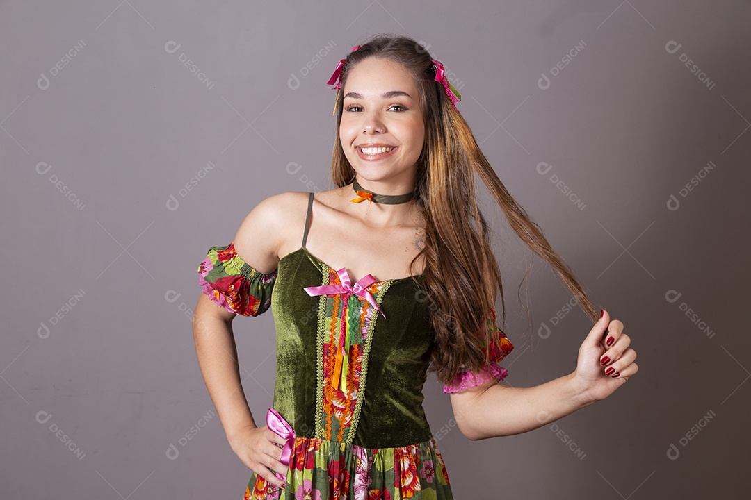 Uma linda jovem com trajes junino pegando em seu cabelo
