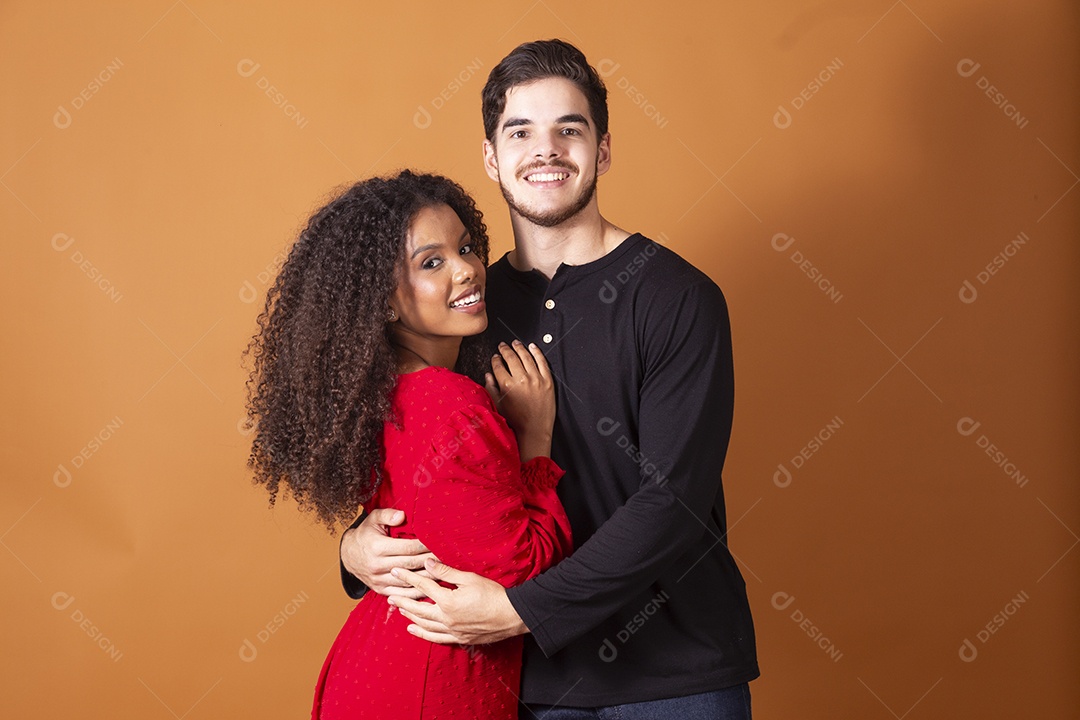 Casal jovem de namorados sobre fundo marrom claro