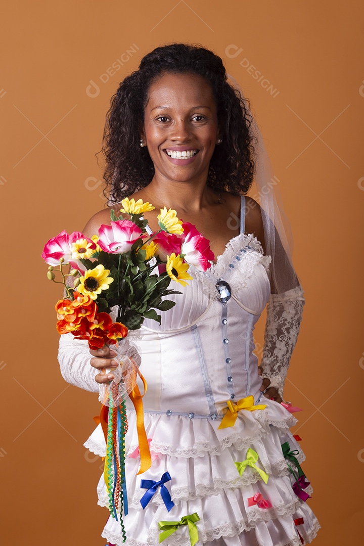 Uma mulher vestida de noiva para festa junina adulta com buquê nas mãos