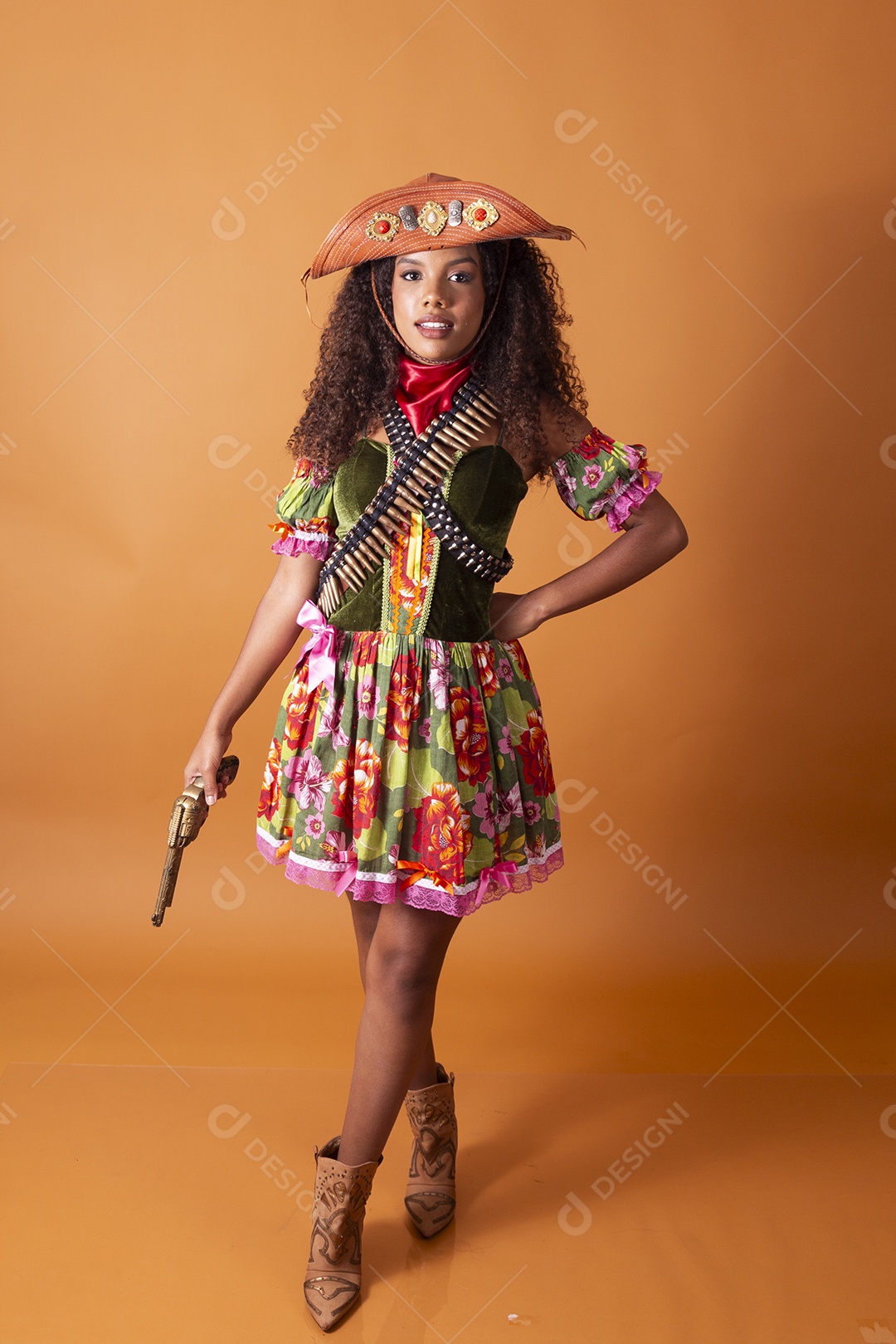 Jovem linda cacheada vestida de cangaceira para festa junina apontando arma