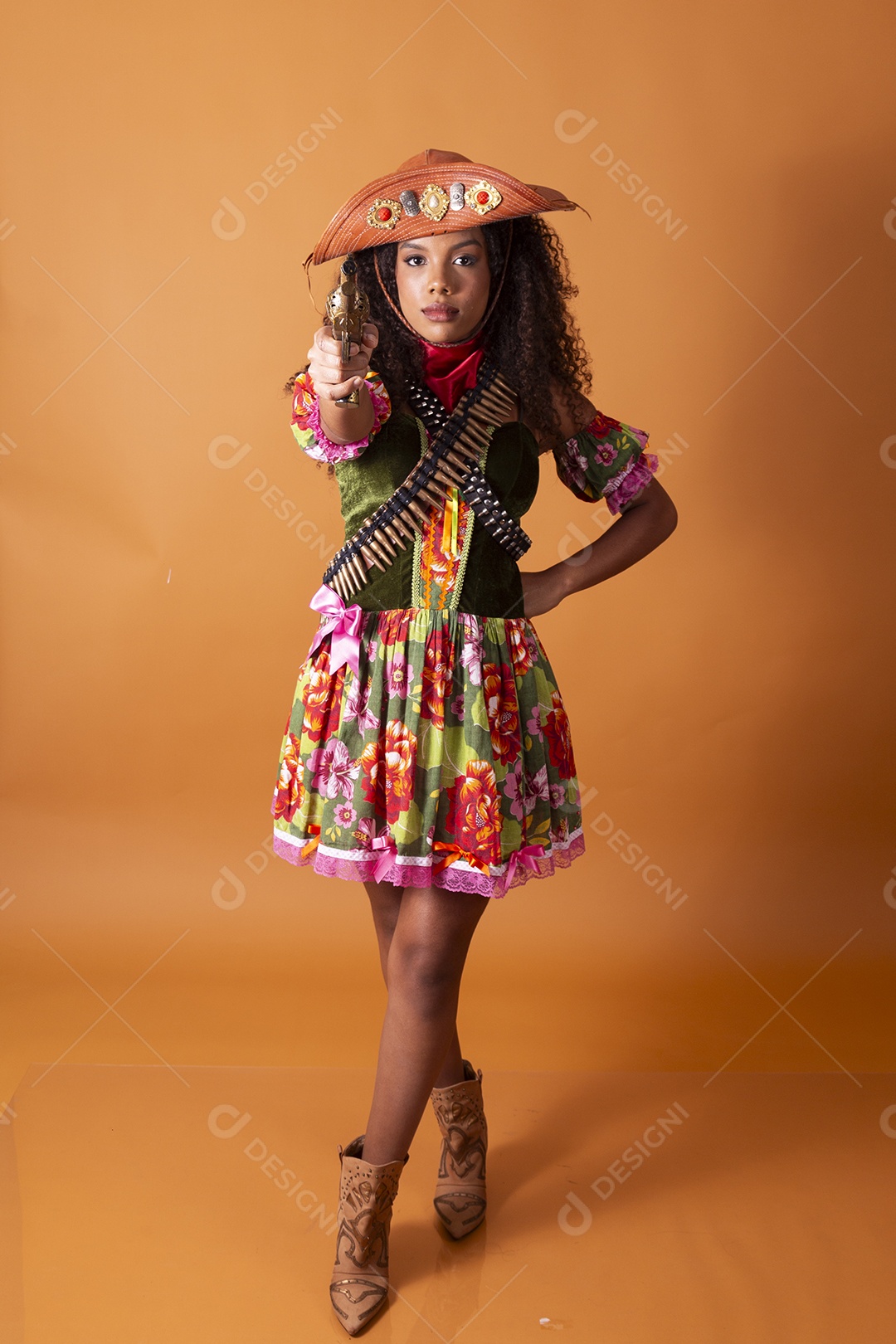 Jovem linda cacheada vestida de cangaceira para festa junina apontando arma