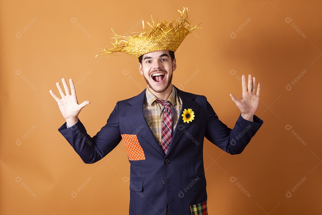 Jovem rapaz surpreso vestido a caráter para festa junina com mãos pra cima