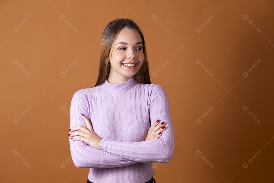 Uma linda jovem de cabelos claros com blusa lilás com braços cruzados