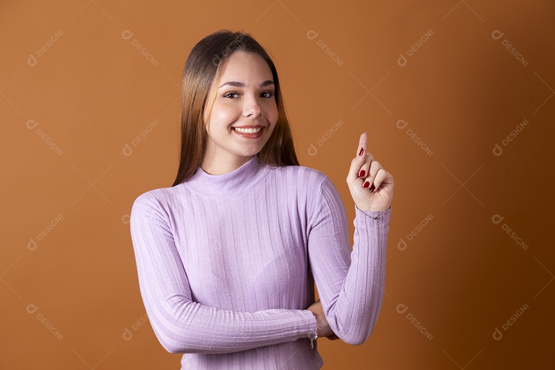Uma linda jovem de cabelos claros com blusa lilás apontando pra cima