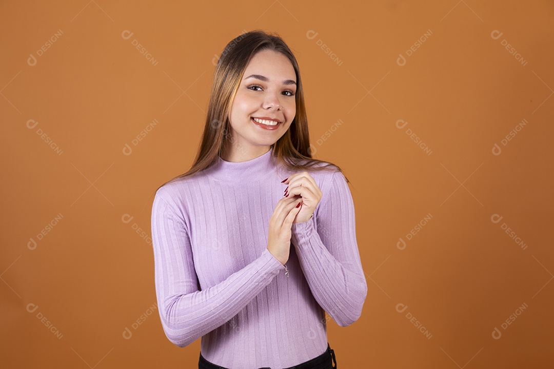 Uma linda menina jovem com mãos dadas e blusa lilás