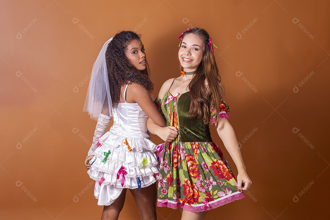 Duas garotas trajadas para quadrilha e felizes