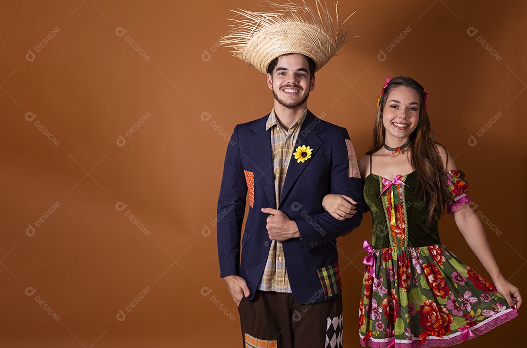 Casal de quadrilheiros de braços dados e sorrindo