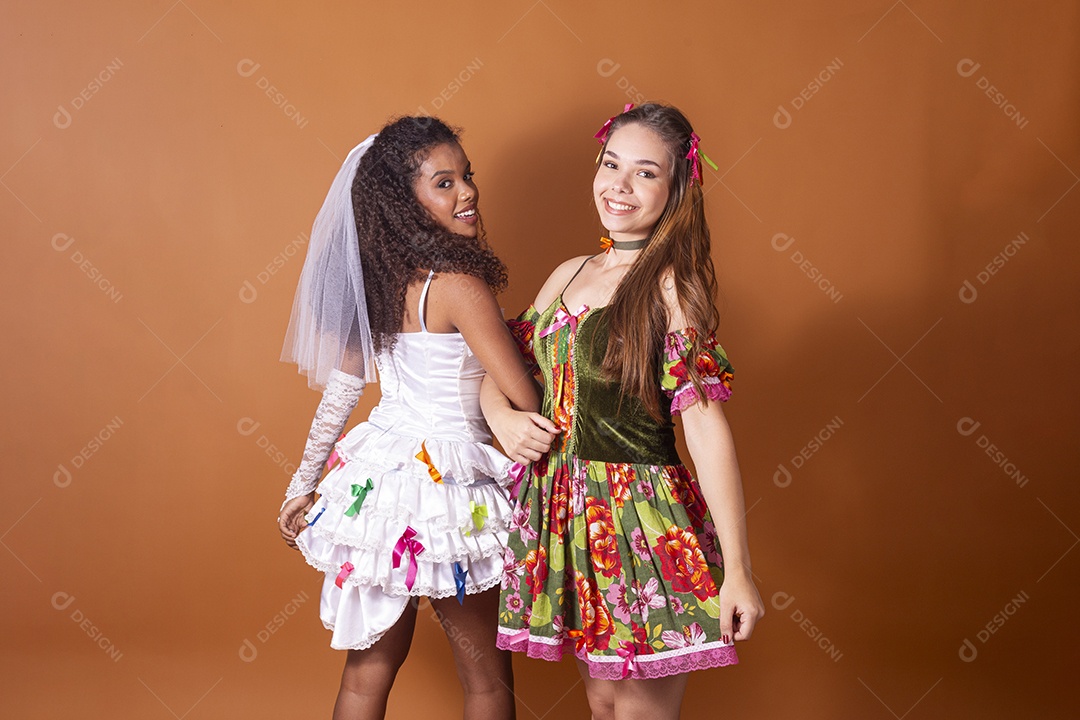 Duas garotas trajadas para quadrilha e felizes