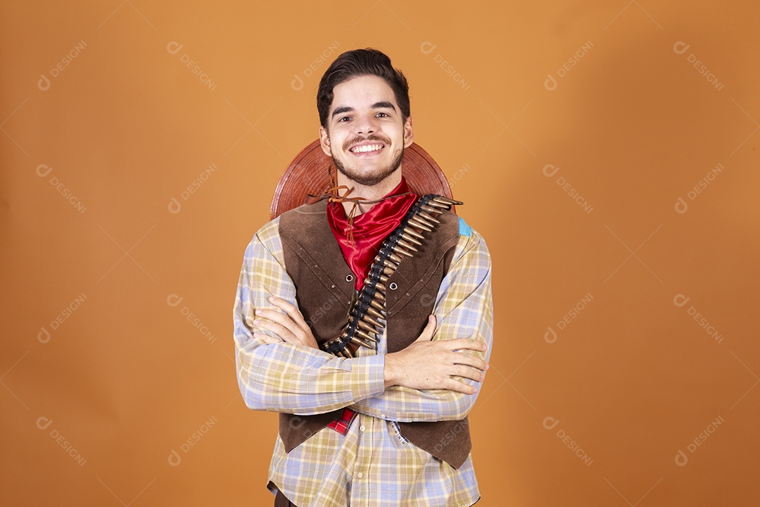 Jovem rapaz vestido a caráter para festa junina com braços cruzados