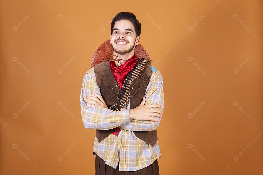 Jovem rapaz vestido a caráter para festa junina com braços cruzados