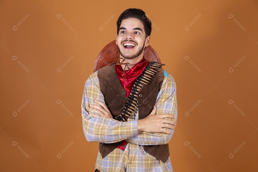 Jovem rapaz vestido a caráter para festa junina com braços cruzados