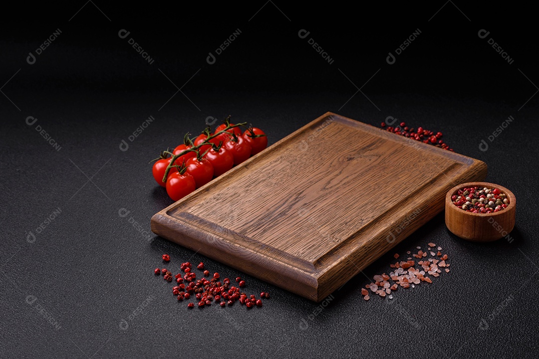 Fundo preto com tomate cereja, sal, especiarias e ervas. Ingredientes culinários