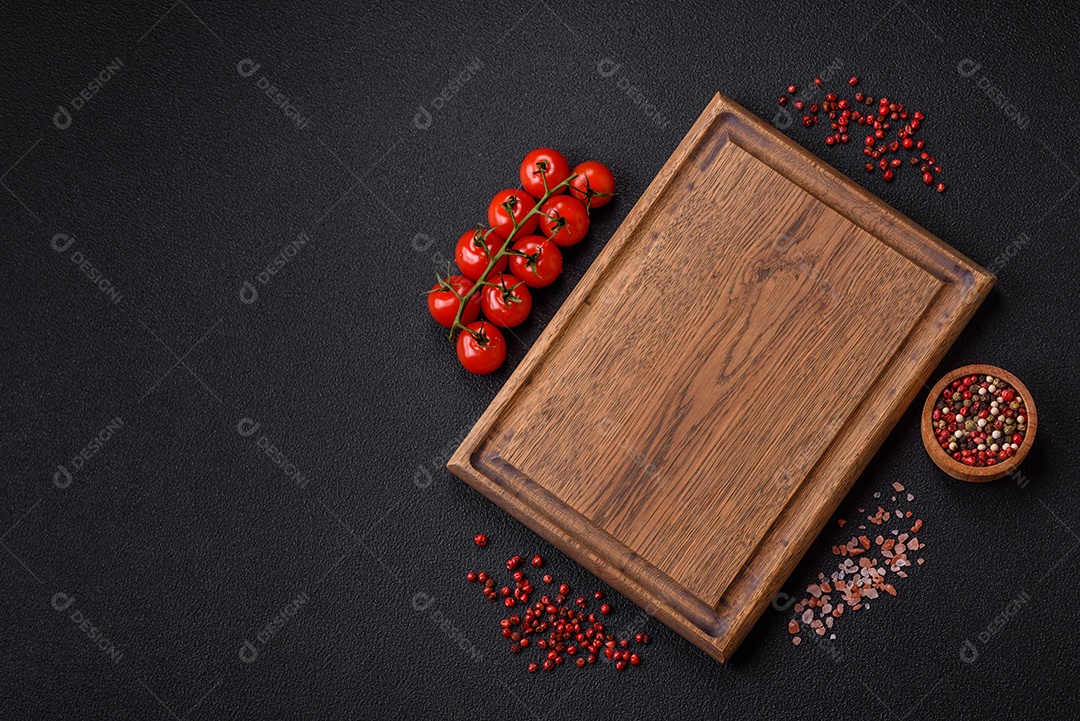Fundo preto com tomate cereja, sal, especiarias e ervas. Ingredientes culinários