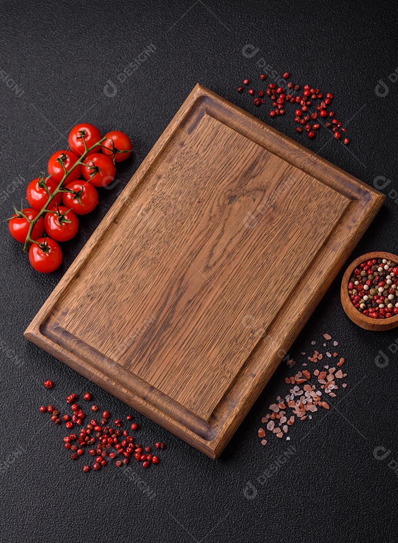 Fundo preto com tomate cereja, sal, especiarias e ervas. Ingredientes culinários