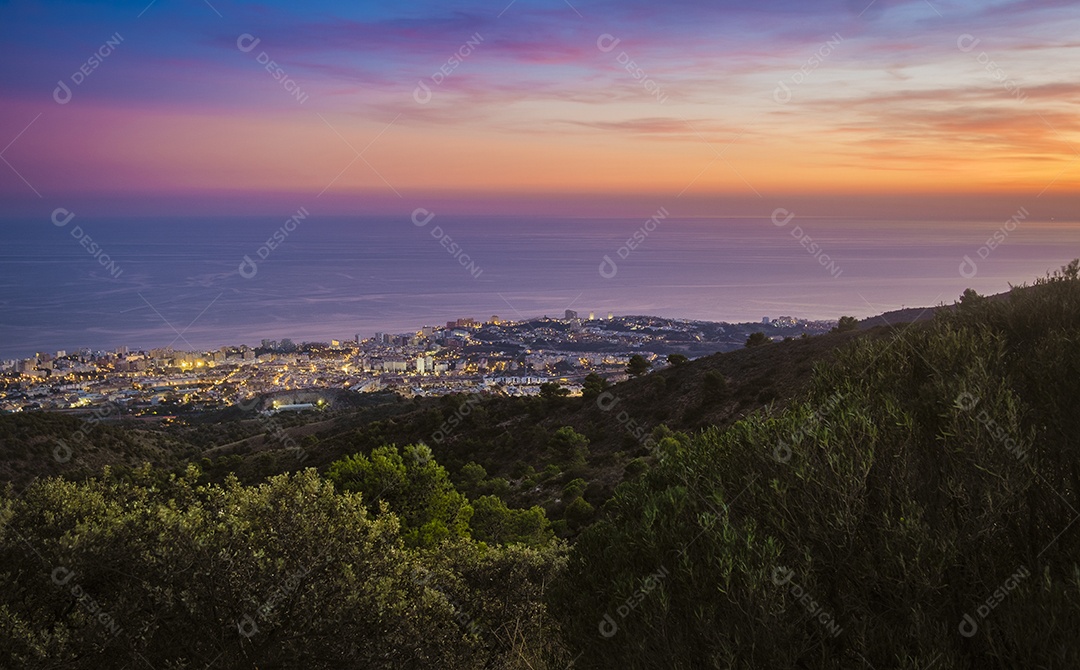Vista da cidade de Benalmádena com mar ao fundo desde o topo da montanha ao entardecer