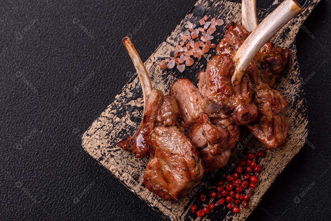 Deliciosa carne suculenta com osso ou costela de cordeiro ou vitela grelhada com sal, especiarias e ervas