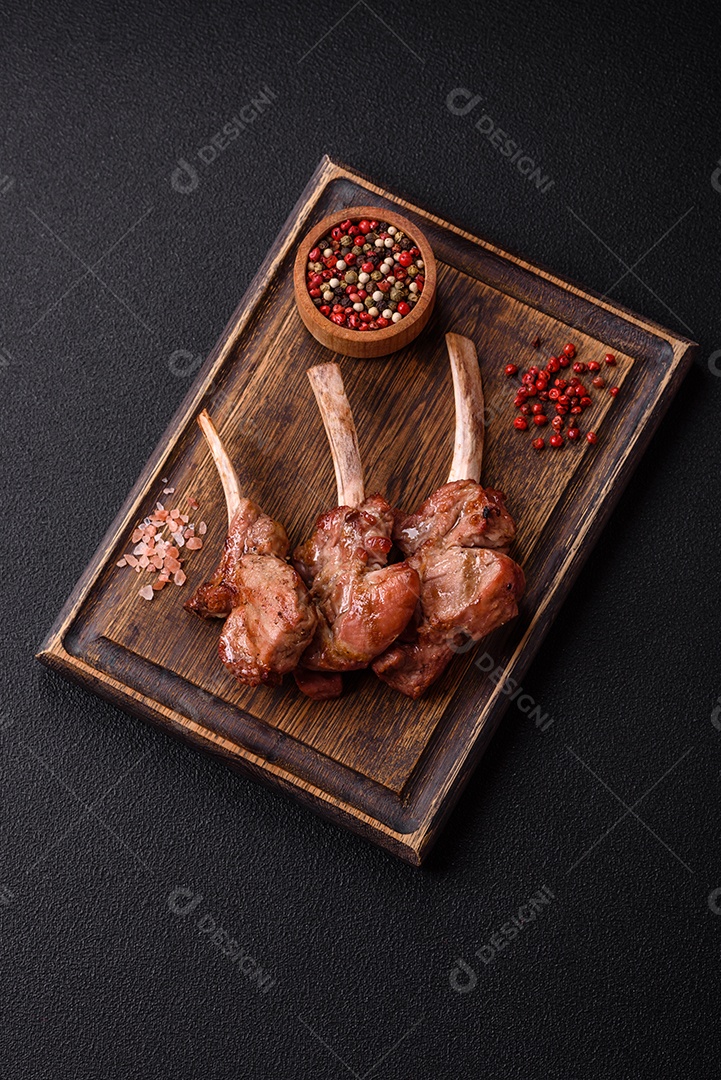 Deliciosa carne suculenta com osso ou costela de cordeiro ou vitela grelhada com sal, especiarias e ervas