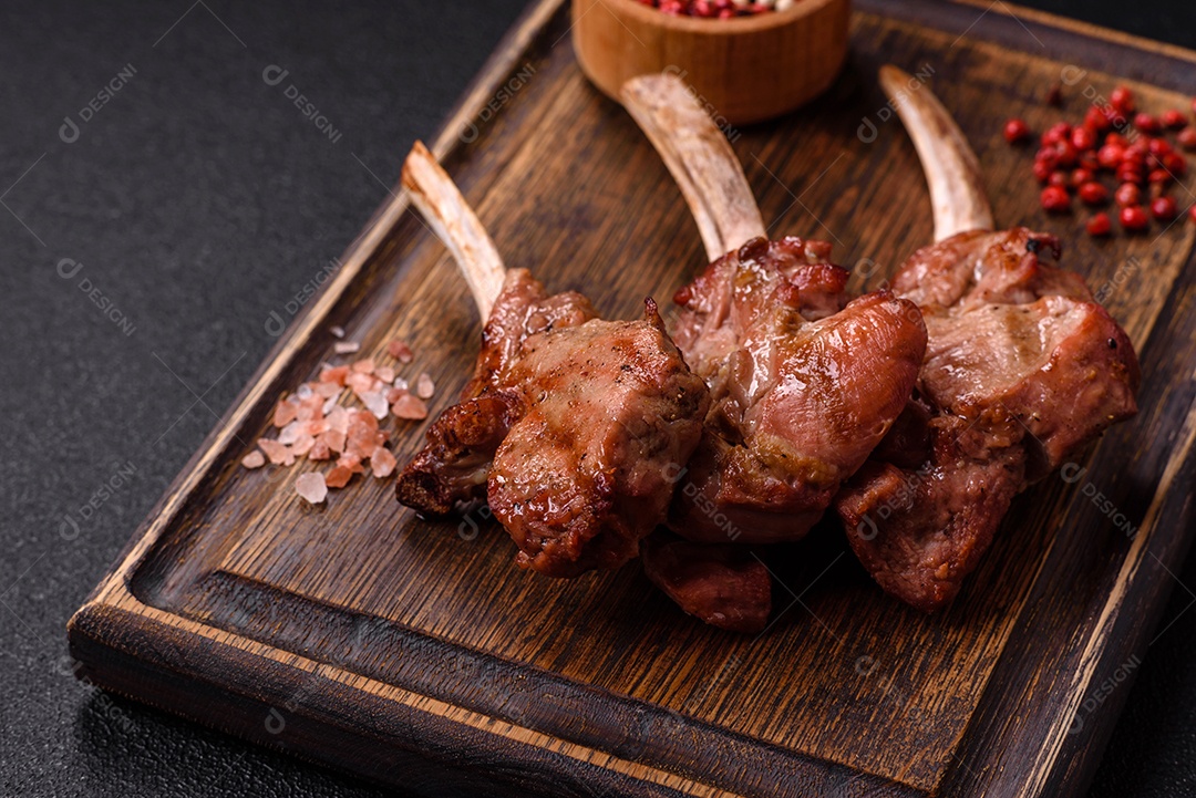 Deliciosa carne suculenta com osso ou costela de cordeiro ou vitela grelhada com sal, especiarias e ervas