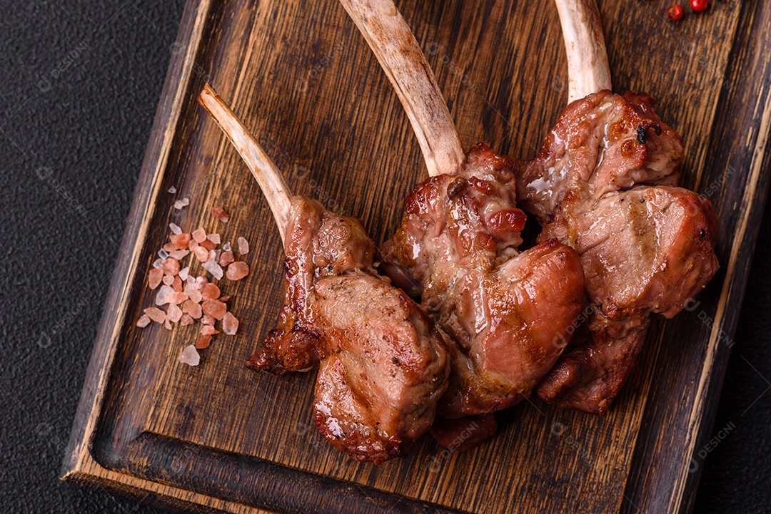 Deliciosa carne suculenta com osso ou costela de cordeiro ou vitela grelhada com sal, especiarias e ervas