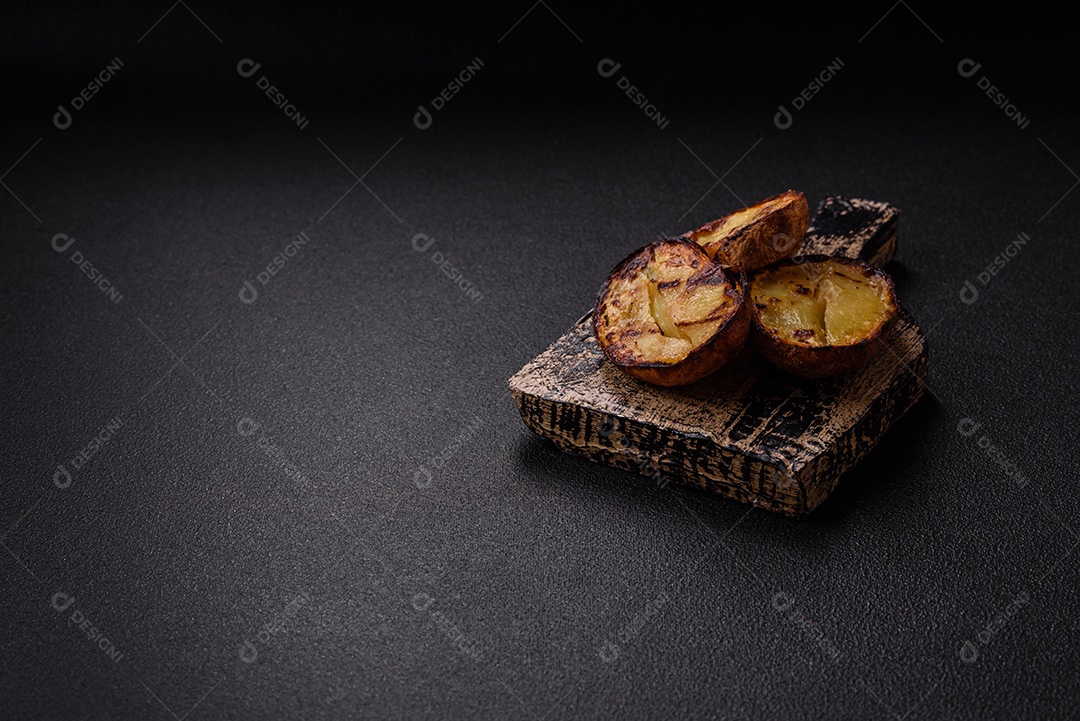 Deliciosas metades de batata com casca assadas na grelha com sal, especiarias e ervas