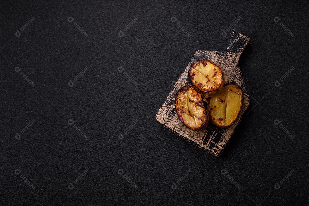 Deliciosas metades de batata com casca assadas na grelha com sal, especiarias e ervas