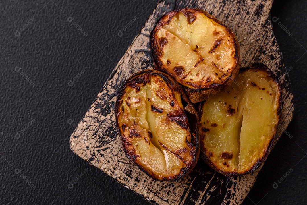 Deliciosas metades de batata com casca assadas na grelha com sal, especiarias e ervas