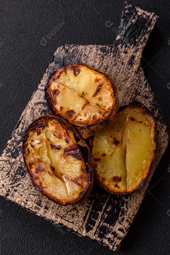 Deliciosas metades de batata com casca assadas na grelha com sal, especiarias e ervas