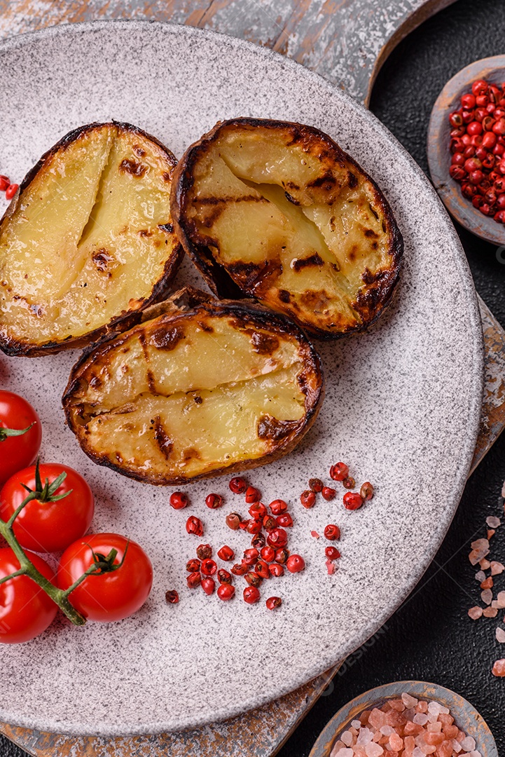 Deliciosas metades de batata com casca assadas na grelha com sal, especiarias e ervas