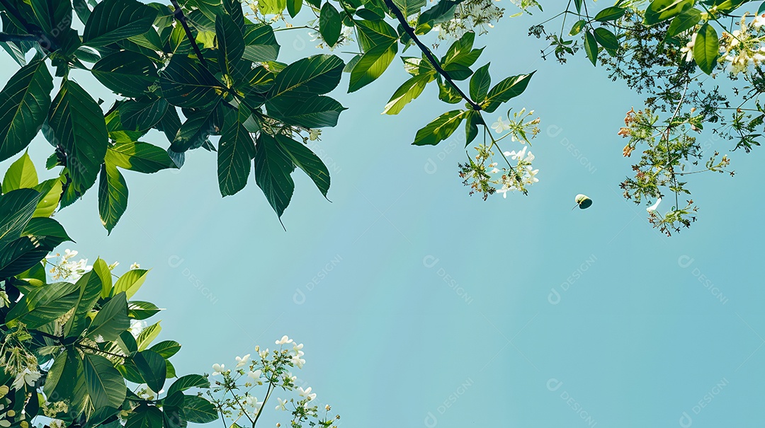 Folhas verdes exuberantes e flores em plena floração contra um céu azul claro