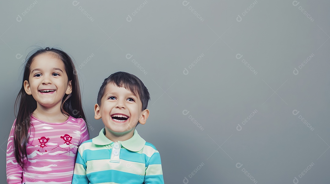 Duas crianças sorrindo sobre fundo cinza