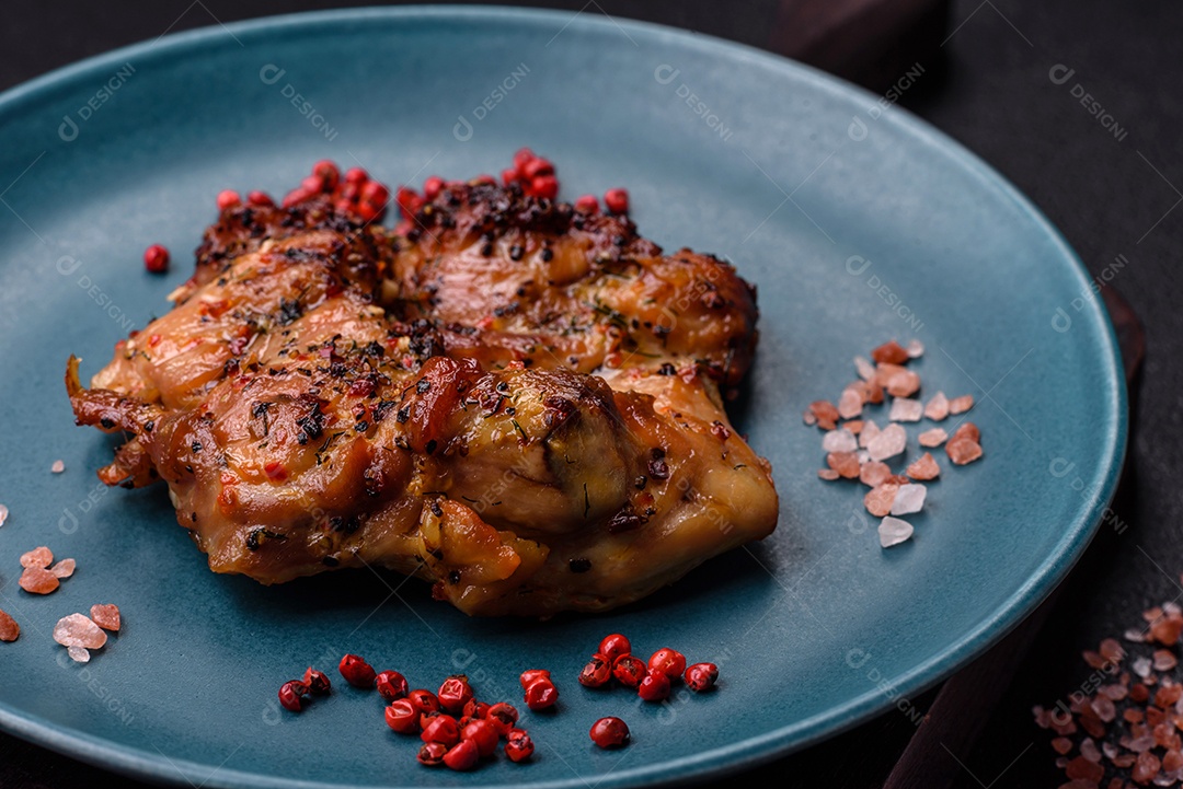 Delicioso bife de frango suculento com sal, especiarias e ervas sobre um fundo escuro de concreto