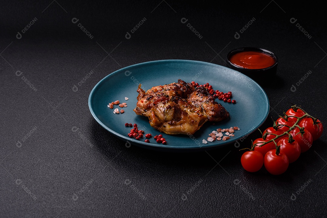 Delicioso bife de frango suculento com sal, especiarias e ervas sobre um fundo escuro de concreto