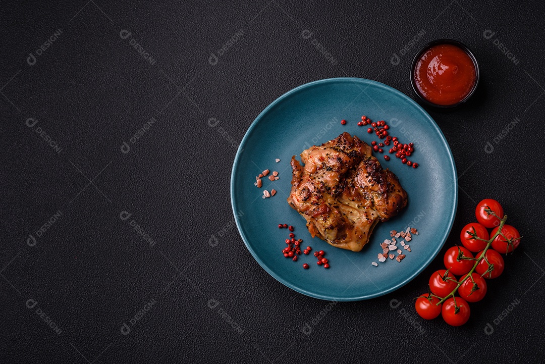 Delicioso bife de frango suculento com sal, especiarias e ervas sobre um fundo escuro de concreto