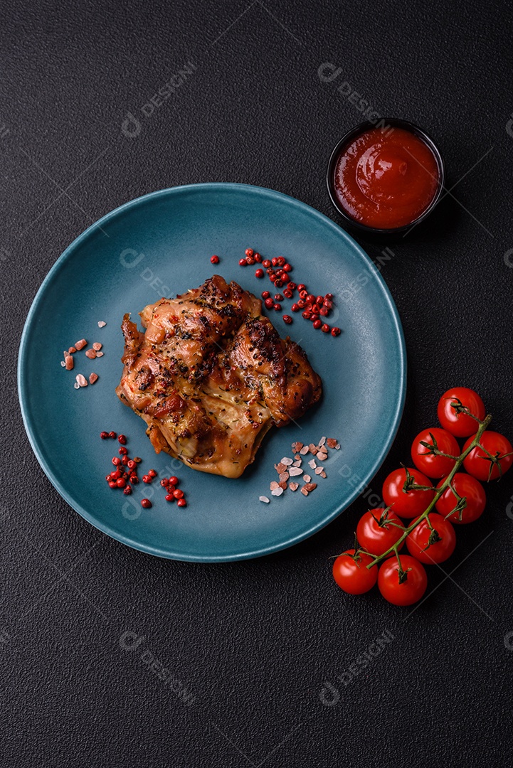 Delicioso bife de frango suculento com sal, especiarias e ervas sobre um fundo escuro de concreto