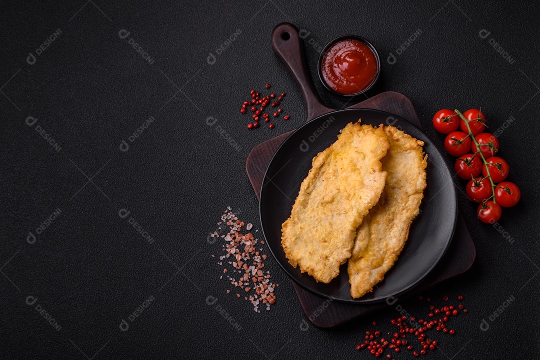 Deliciosas costeletas de frango suculentas em massa com sal, especiarias e ervas sobre um fundo escuro de concreto