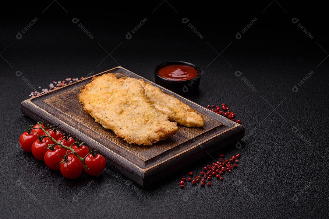 Deliciosas costeletas de frango suculentas em massa com sal, especiarias e ervas sobre um fundo escuro de concreto