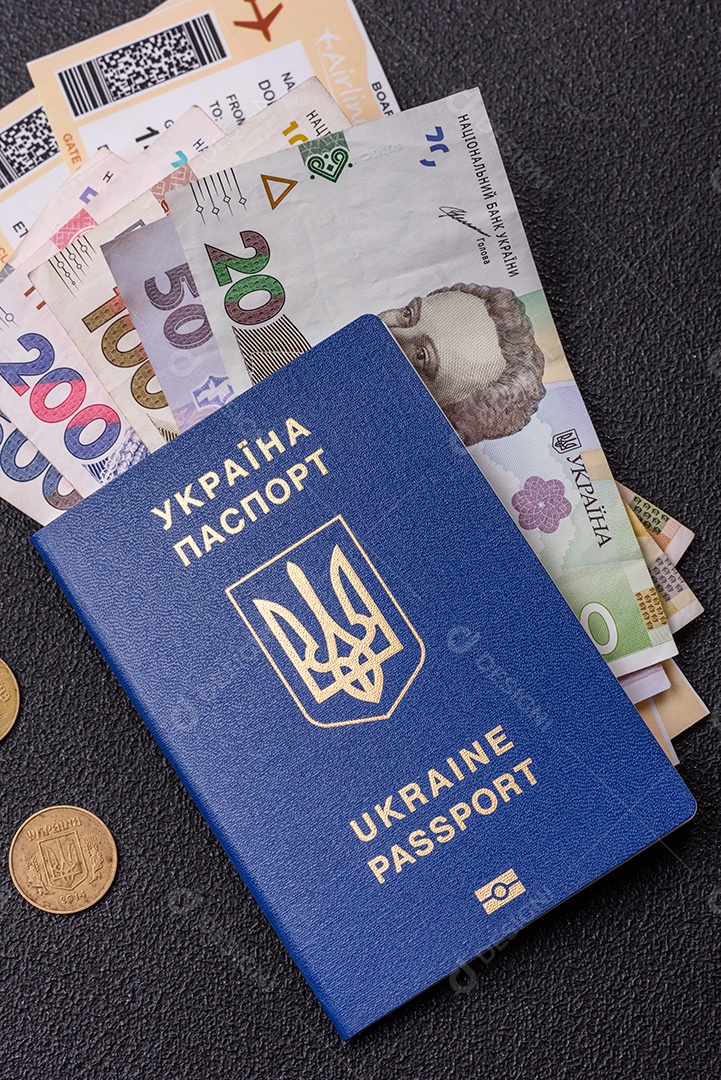 Passaporte ucraniano biométrico, passagens aéreas e dinheiro em um fundo escuro de concreto. Antecedentes conceituais sobre o tema turismo e viagens
