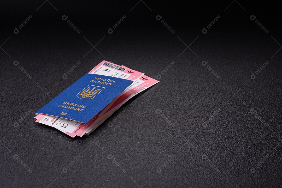 Passaporte ucraniano biométrico, passagens aéreas e dinheiro em um fundo escuro de concreto. Antecedentes conceituais sobre o tema turismo e viagens