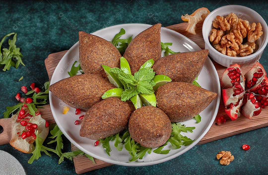 Quibes fritos em uma travessa com bandas de limãos