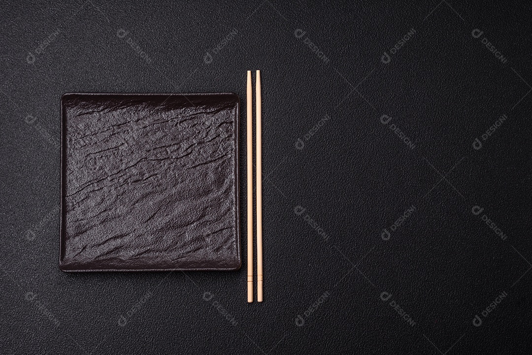 Placa redonda de cerâmica vazia em fundo de concreto texturizado escuro. Talheres, preparação para o jantar