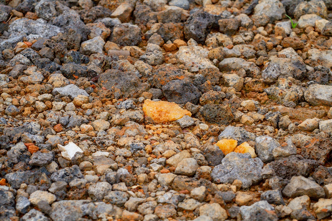 Pedras conhecidas como brita em uma estrada rural