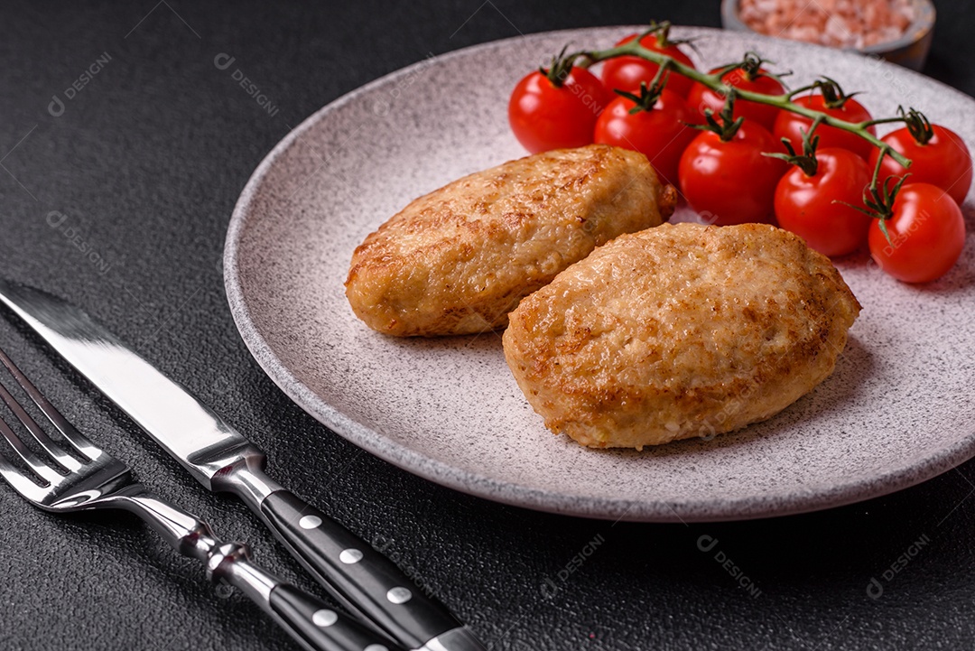 Deliciosas costeletas picadas fritas frescas com especiarias e ervas sobre um fundo escuro de concreto