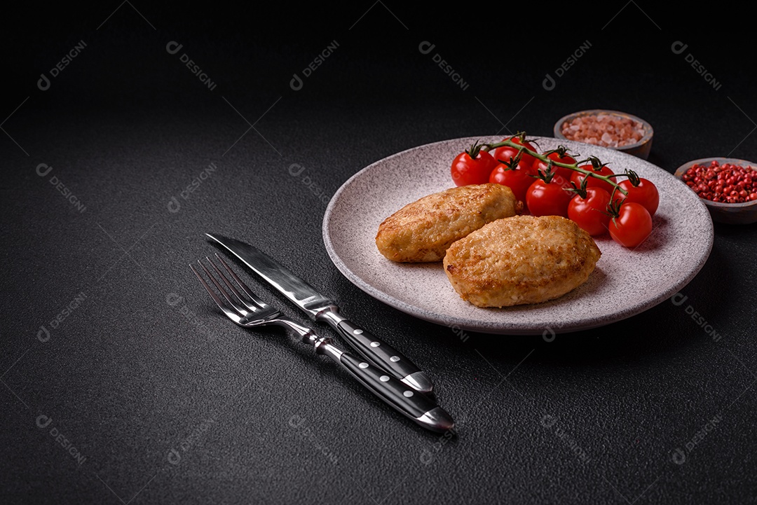 Deliciosas costeletas picadas fritas frescas com especiarias e ervas sobre um fundo escuro de concreto