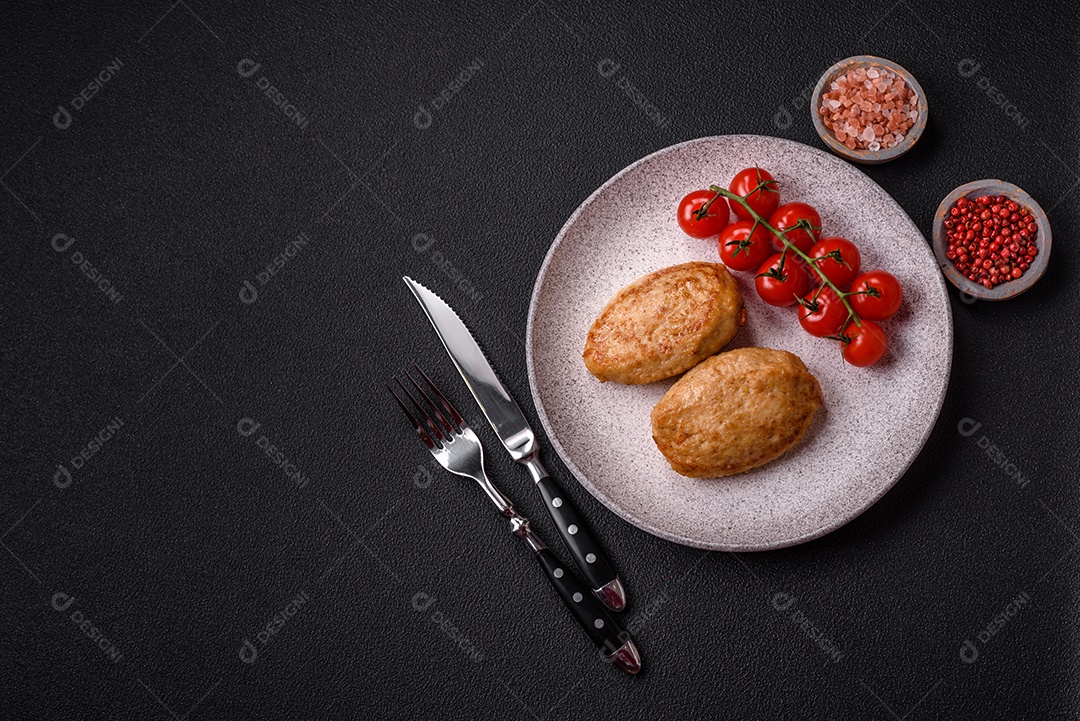 Deliciosas costeletas picadas fritas frescas com especiarias e ervas sobre um fundo escuro de concreto