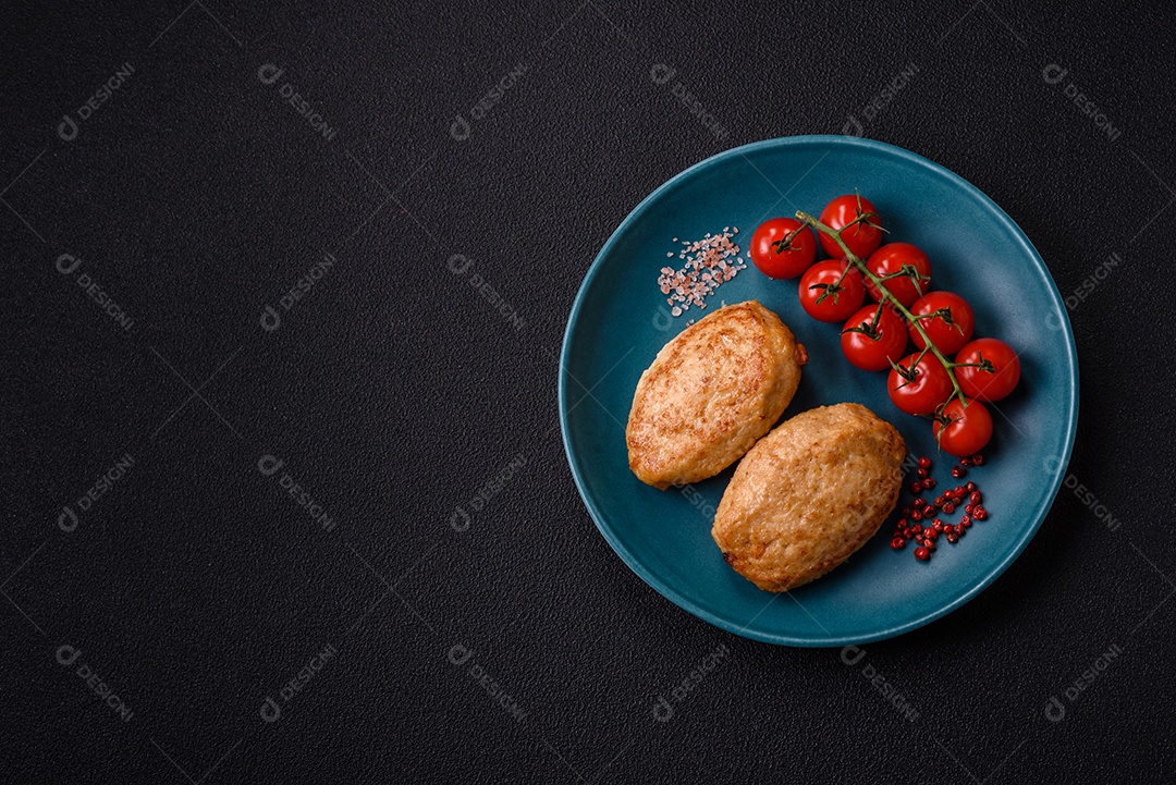 Deliciosas costeletas picadas fritas frescas com especiarias e ervas sobre um fundo escuro de concreto
